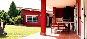 a red pole on the side of a house at Guirigay CASA CON PISCINA in Muros de Nalón