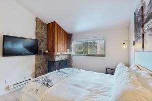 een slaapkamer met een bed en een flatscreen-tv bij Rustic Relaxation in Winter Park in Winter Park +14 foto's