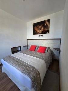 a bedroom with a large bed with two red pillows at La Casa de Iya in Las Indias
