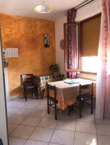 a dining room with a table and chairs and a window at Le Fontanelle Apartment in Siniscola +10 photos