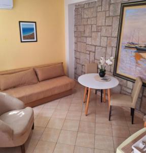 a living room with a couch and a table at Apartments Mitrovići Miločer in Sveti Stefan