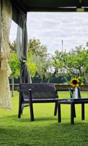 a park bench and a table with a vase on it at Itaca in Lido di Fermo