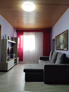 a living room with a couch and a window at ALOJAMIENTO ENTERO CON PISCINA Y JARDIN. in Ourense