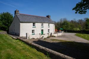 a white house with a driveway in front of it at Rhostwarch Old Farmhouse Newport, Pembrokeshire in Eglwyswrw