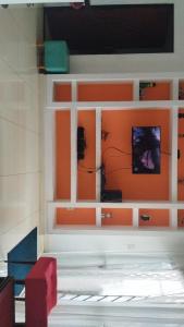 een kamer met oranje muren en een tv aan de muur bij Casa Mussurunga in Salvador