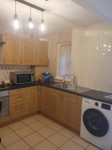 a kitchen with a sink and a washing machine at Four Large Double With Ensuites in Abbey Wood