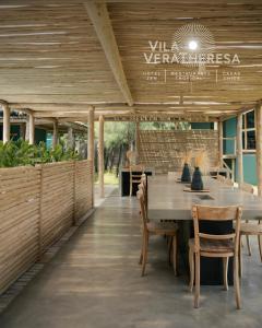 a dining room with a wooden table and chairs at Hotel VilaVeraTheresa in Fortim
