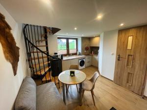 a living room with a table and a kitchen at Apartamenty QUER SPA Jacuzzi i Sauna in Bańska Niżna