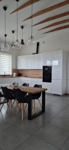 Una cocina con una mesa de madera y algunas sillas. en Storms 4, en Sudmalkalni