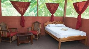 a bedroom with a bed and two chairs and a window at Maniti Eco-Lodge in Francisco de Orellana