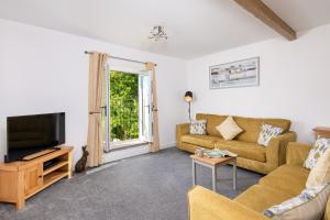 a living room with a couch and a tv at Church House Barn Lake District & Solway Coast with Solway Firth views in Silloth