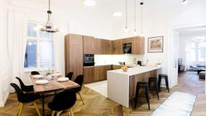 a kitchen and living room with a table and chairs at Luxury Apartment by Hi5 - Best Location 3-br in Budapest