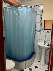 塔克纳Hotel lucero real的浴室设有蓝色的浴帘和水槽