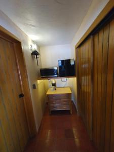 a small room with a television and a wooden door at Sandy Shores Cabaña 6A in La Paz