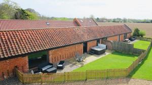 an aerial view of a house with a fence at Brick Kiln Barns in North Walsham