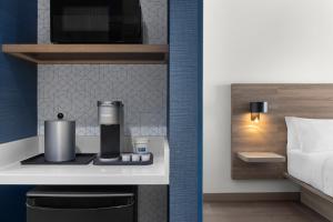 a hotel room with a coffee maker on a counter at Holiday Inn Express Montreal Airport - St-Laurent by IHG in Montréal