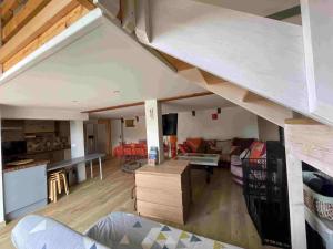 a living room and kitchen with a loft at La Grange de Melaual in Soulages-Bonneval