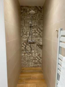 a shower in a bathroom with a tile wall at Casinha de Roliça in Roliça +7 photos