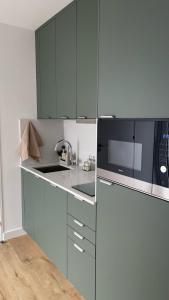 a kitchen with blue cabinets and a sink and a microwave at Casinha de Roliça in Roliça
