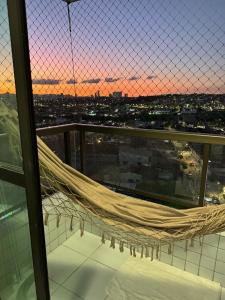 a hammock on the top of a building with a sunset at Perfeito Ap Caruaru in Caruaru