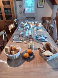 a wooden table with bread and bowls of food on it at Les pommiers in Honfleur