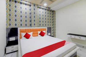 a bedroom with a white bed with red pillows at Hotel O One Plus Inn in Itwāri +17 photos