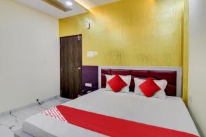 a bedroom with a bed with red and white pillows at Hotel O One Plus Inn in Itwāri