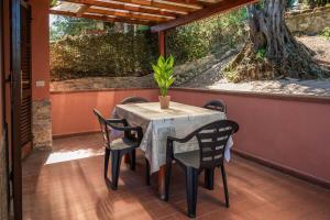 una mesa con sillas y una maceta en un patio en Villa Agello Vista Lago, en Agello
