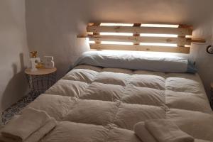 a bedroom with two beds and a wooden headboard at Casita rural Els voladorets in Torre de Endoménech
