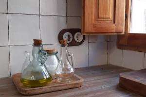 two glass bottles on a cutting board on a kitchen counter at Casita rural Els voladorets in Torre de Endoménech