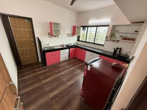 a kitchen with red cabinets and a refrigerator at Hope in Udupi