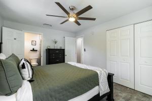 a bedroom with a bed and a ceiling fan at Modern & Tasteful Pool Home in Gainesville +46 photos