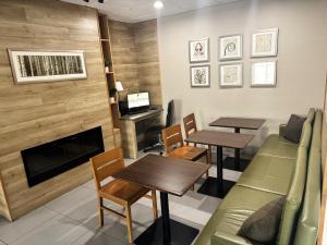 a waiting room with two tables and a fireplace at Country Inn & Suites by Radisson, Midway - Tallahassee West in Midway