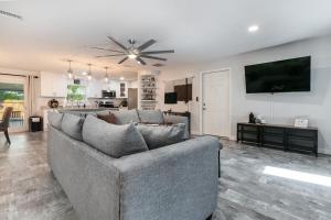a living room with a couch and a flat screen tv at Modern & Tasteful Pool Home in Gainesville