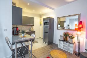 Appartement Place Monge 3 Guests في باريس: مطبخ صغير مع طاولة وقمة كونتر