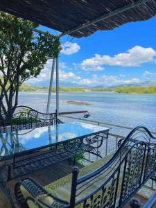 Ein Tisch und Stühle auf einer Terrasse mit Blick auf einen Fluss in der Unterkunft Hotel Fantazia in Shkodra