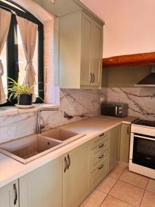 a kitchen with white cabinets and a sink at Skandalis Apartments with pool in Chorafakia