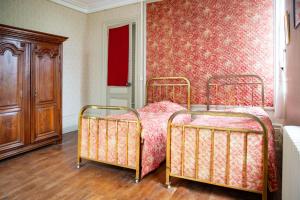 a bedroom with two beds and a red wall at Chateau de Maisonneuve in Leigné-les-Bois +16 photos