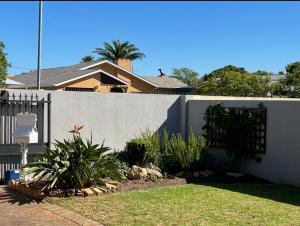 una cerca frente a una casa con plantas en Strand cosy 2 bedroom house, en Strand