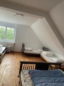 a attic room with two beds and a window at Maison à Lilia in Plouguerneau