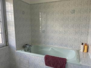 a bath tub in a bathroom with a red towel at Maison à Lilia in Plouguerneau