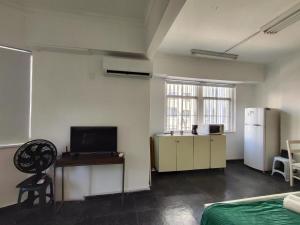 a room with a refrigerator and a table and a chair at Santos Dumont Apê in Rio de Janeiro +32 photos