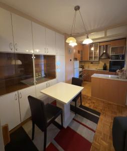 a kitchen with a white table and chairs in a room at Center Apartment 1 Sisak in Sisak