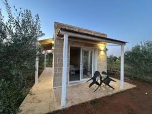 a house with two chairs sitting on a patio at Agricampeggio Tenuta Ferrario in Baia Verde