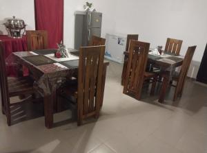 ein Esszimmer mit einem Tisch und Stühlen sowie einem Kühlschrank in der Unterkunft Beragala Estate and Resort in Haputale