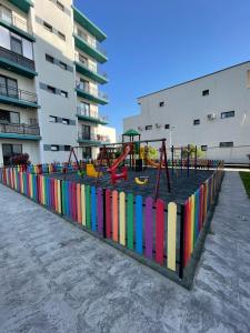 a playground with a colorful fence next to a building at Ayan Residence in Năvodari