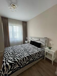 a bedroom with a zebra print bed and a window at Ayan Residence in Năvodari