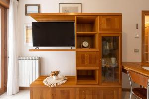 a large wooden entertainment center with a flat screen tv at L'Angolo Fiorito con terrazza e in pieno centro in Grado