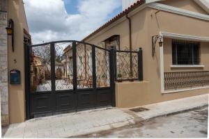 a house with a black door and a balcony at Strofilia House Near ATH Airport in Markopoulo