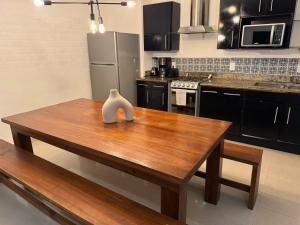 a kitchen with a wooden table with a vase on it at TENDA Comfortable Apartments in Playa del Carmen +2 photos